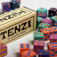 Load image into Gallery viewer, Close up to the Tenzi packaging with a blue, magenta, and orange dice arranged on a white background.
