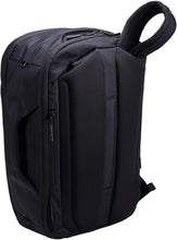 Load image into Gallery viewer, Angled back panel view of the backpack showing the shoulder straps being hidden in a small pocket behind them. 

