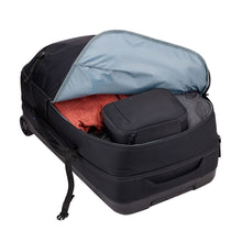 Load image into Gallery viewer, The black wheeled duffle partly unzipped and filled with clothes and travel accessories. 
