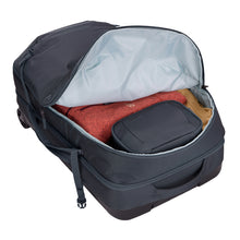 Load image into Gallery viewer, Interior view of the Dark Slate duffle bag partly unzipped, and filled with clothes and travel accessories. 
