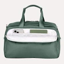 Load image into Gallery viewer, Front panel view of the bag with the pocket open. A phone a small notepad are tucked into the compartments.
