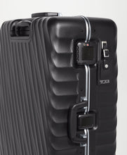 Load image into Gallery viewer, Close up to the side panel of the suitcase showing the tag, grab handle, clasps, and TSA approved lock. 
