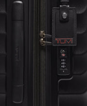 Load image into Gallery viewer, Close up to the side panel. It features a grab handle, a tag, and a TSA approved three-digit combo lock. 
