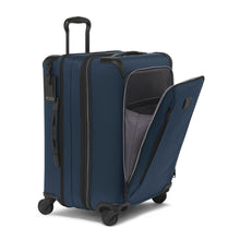 Load image into Gallery viewer, Angled front view of the blue suitcase with the front panel&#39;s pocket unzipped. 
