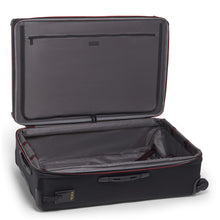 Load image into Gallery viewer, Interior view of the black suitcase showing a zipper-closing panel divider and a set of straps to hold your contents. 
