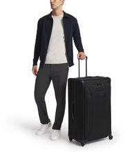 Load image into Gallery viewer, A young man holding the suitcase by the extended telescopic handle. 
