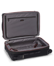Load image into Gallery viewer, Interior view of the black suitcase, showing a zipper-closing panel divider with a pocket on the front, and a set of straps on the back panel to hold your contents in place. 
