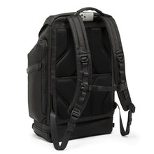 Load image into Gallery viewer, Angled back view of the backpack, showing a cellphone placed inside the slot underneath the grab handle. 
