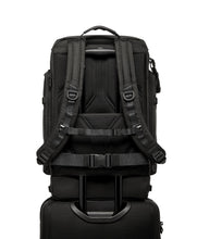 Load image into Gallery viewer, Back panel view showing attachment feature. A suitcase&#39;s telescopic handle can be passed through to hold the backpack in place. 
