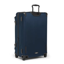 Load image into Gallery viewer, Angled back panel view of the blue soft sided suitcase with black accents. 
