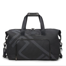 Load image into Gallery viewer, A black TUMI travel satchel with the logo printed across in light gray It features a top carry handle, detachable shoulder strap, and a front pocket. 
