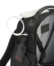 Load image into Gallery viewer, Close up to the backpack&#39;s Tag, where a hidden panel features a USB plug to charge your devices. Power bank not included. 
