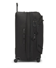 Load image into Gallery viewer, Side panel view of the suitcase with the expandable feature unzipped. It features a grab handle, a contact information tag, and a TSA approved three-digit combination lock. 

