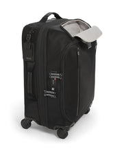 Load image into Gallery viewer, Angled side panel view of the suitcase with the front panel&#39;s pocket unzipped. The side panel features a tag, a grab handle, and a TSA approved three-digit combination lock. 
