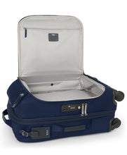 Load image into Gallery viewer, The indigo suitcase laid on its back with the front panel compartment unzipped and lifted. 
