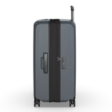 Load image into Gallery viewer, Side panel view of the suitcase showing a handle and the TSA three-digit combination lock.
