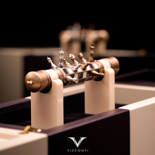 Load image into Gallery viewer, The Visconti Checkmate is set on its display box rest with some of the magnetic chess pieces placed on it. 
