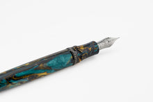 Load image into Gallery viewer, Close up to the grip section of the Earth Origins Fountain Pen. It has a black ring with the words HOMO SAPIENS engraved. The nib is a light gray color and is made of 750 gold. 
