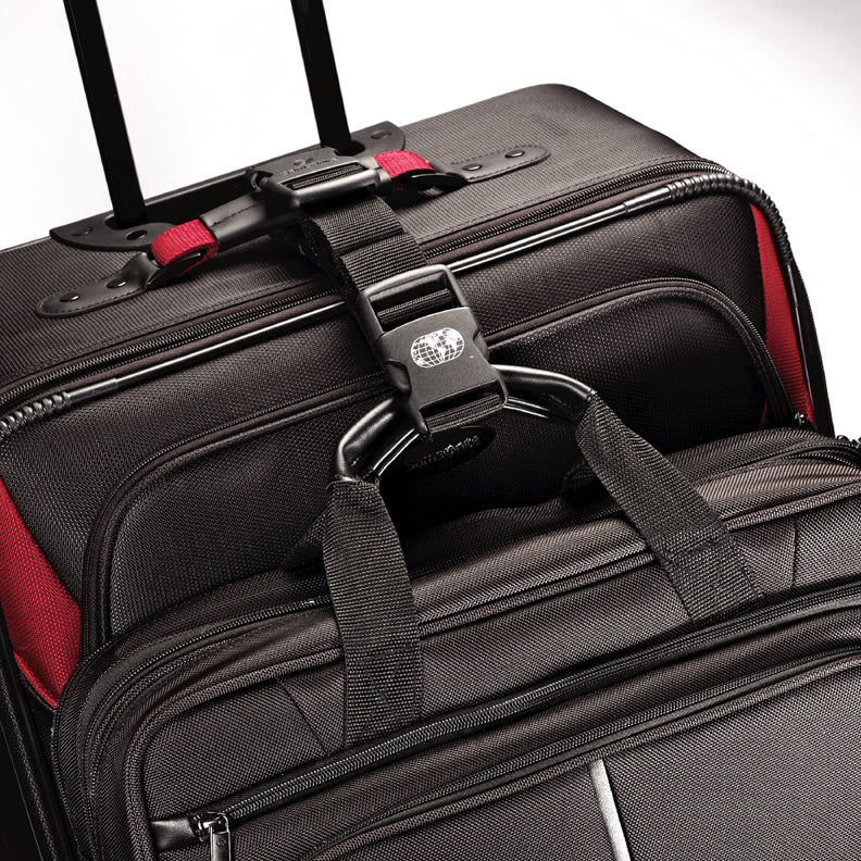 Close up to the strap attaching a suitcase and briefcase together by the handles. 