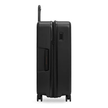 Load image into Gallery viewer, Side panel view of the black medium suitcase. It features a grip handle. 
