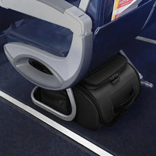 Load image into Gallery viewer, The black cabin spinner resting on it's back panel under a plane seat. 
