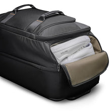 Load image into Gallery viewer, Angled interior close up to the black duffle bag's top panel compartment. It is holding a pair of white sneakers.
