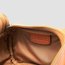 Load image into Gallery viewer, Close-up of the interior of a tan leather bag, showing a stitched brown leather  DORADO patch 
