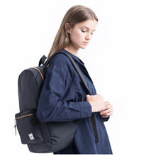 Load image into Gallery viewer, A young woman carrying the black backpack.
