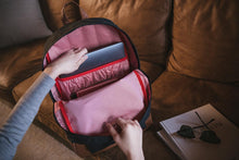 Load image into Gallery viewer, A pair of hands taking a laptop out from the backpack's main interior compartment.
