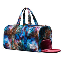 Load image into Gallery viewer, Angled front view of the Summer Tie Dye Novel Duffle Bag. The side panel's shoe compartment is unzipped. 
