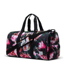Load image into Gallery viewer, Angled front view of the Pixel Floral Novel Duffle bag. 
