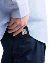 Load image into Gallery viewer, A hand pulling the black Roy Wallet wallet from their pants pocket.
