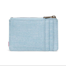 Load image into Gallery viewer, Back view of the light denim Herschel  RFID Oscar Wallet with a zippered main compartment and external card slots.
