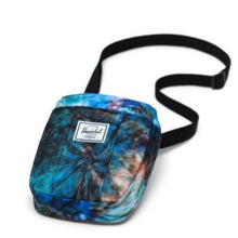 Load image into Gallery viewer, The Summer Tie Dye Crossbody Cruz bag laid on its back with the adjustable shoulder strap laid behind it. 
