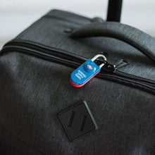 Load image into Gallery viewer, The navy and red lock securing a set of suitcase zippers together.
