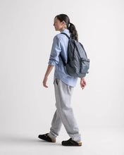 Load image into Gallery viewer, A young woman carrying the packable day pack backpack. 

