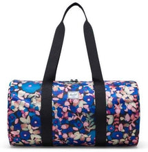 Load image into Gallery viewer, Front view of the Painted Floral packable duffle with the black shoulder straps pulled up.
