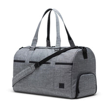 Load image into Gallery viewer, Angled front view of the Raven Crosshatch Novel Tech Duffle Bag. The grab handles are pulled up and the adjustable shoulder strap is laid across the front. 
