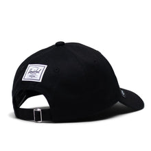 Load image into Gallery viewer, Angled back view of the black cap with a Herschel logo tag.
