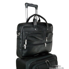 Load image into Gallery viewer, The black briefcase's back panel strap attached to the extended telescopic handle of a suitcase.
