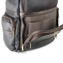 Load image into Gallery viewer, Close up to the front bottom portion of the brown leather backpack. The compartment is unzipped, and features laptop and ID pockets.
