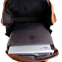 Load image into Gallery viewer, Interior view of the tan leather backpack. It has brown fabric lining, and a laptop tucked inside the compartment. 

