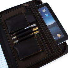 Load image into Gallery viewer, Interior close up to the brown leather portfolio's dedicated compartments. Three pens, a cellphone and a tablet are stored inside. 
