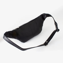 Load image into Gallery viewer, Angled back panel view of the black leather waist pack. It features a zipper-closing pocket.
