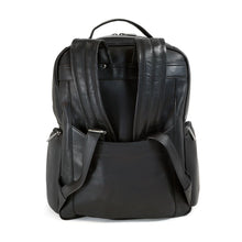 Load image into Gallery viewer, Back panel view of the black leather backpack with the shoulder straps tucked inside the attachment strap.
