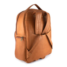 Load image into Gallery viewer, Angled back panel view of the tan leather backpack with the shoulder straps tucked under the attachment strap. 
