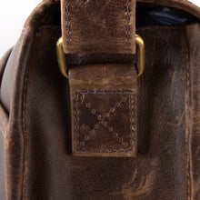 Load image into Gallery viewer, Close up to the stitching on the side panel's adjustable strap stitching to the messenger bag. 
