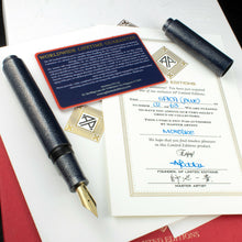 Load image into Gallery viewer, Arrangement of the Fountain Pen with the cap taken off, and placed on top of the presentation boxes and certificates
