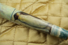 Load image into Gallery viewer, Close up to the Penguin painted on the pen barrel. Placed on top of a golden fabric.
