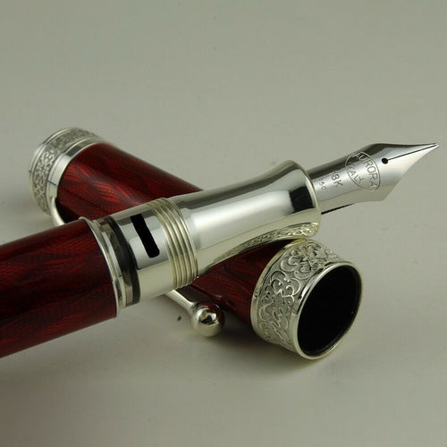 Close up to the pen nib, grip section, and cap. Set on a white background.